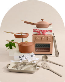 Set of ceramic cookware and kitchen tools on a neutral background
