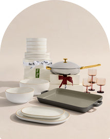 Dinnerware set including bowls, plates, and a pan on a neutral background