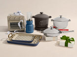 Collection of kitchen appliances including a slow cooker, blender, and baking tray on a beige background.